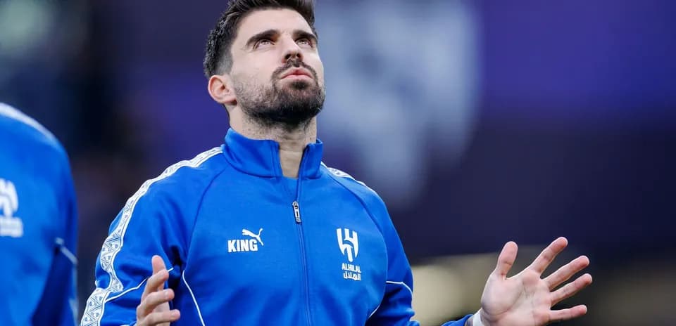 Player in blue tracksuit looking upwards during warm-up