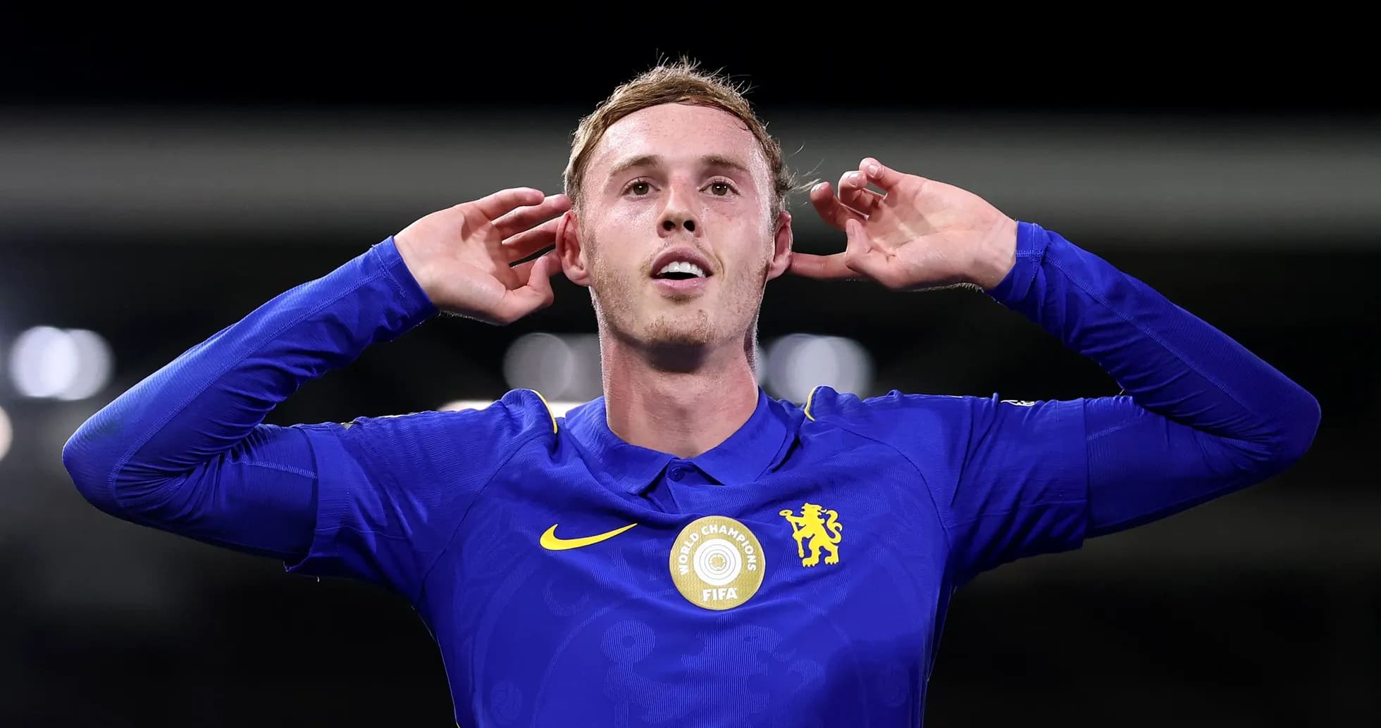 Player celebrating with hands behind ears in blue jersey