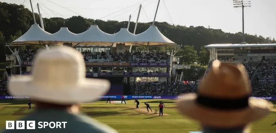 Cricket match in progress with spectators in foreground