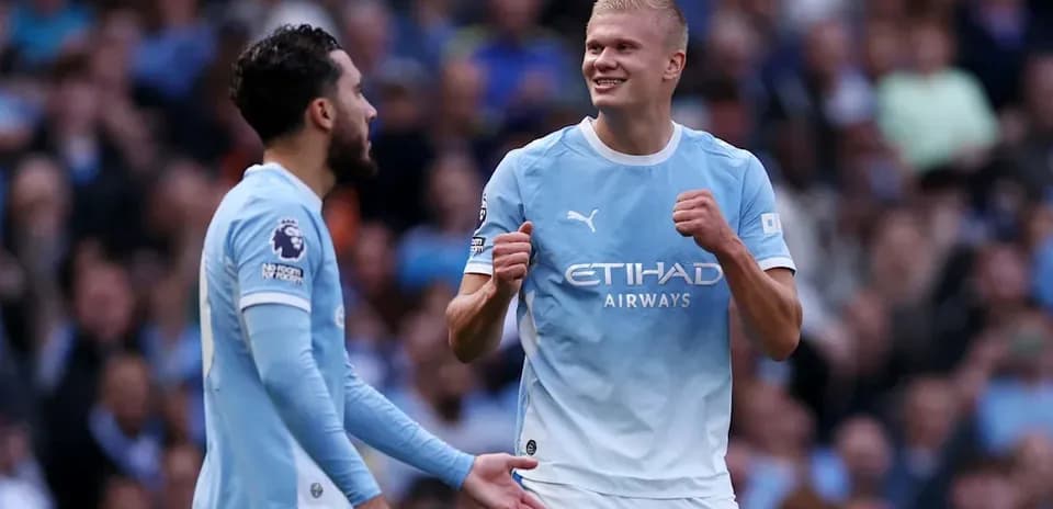 Two Manchester City players celebrating on the field