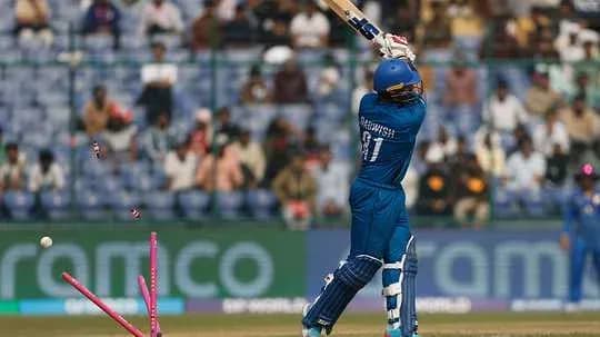 Batsman hitting ball with stumps dislodged