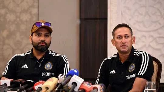 Two coaches at press conference with microphones
