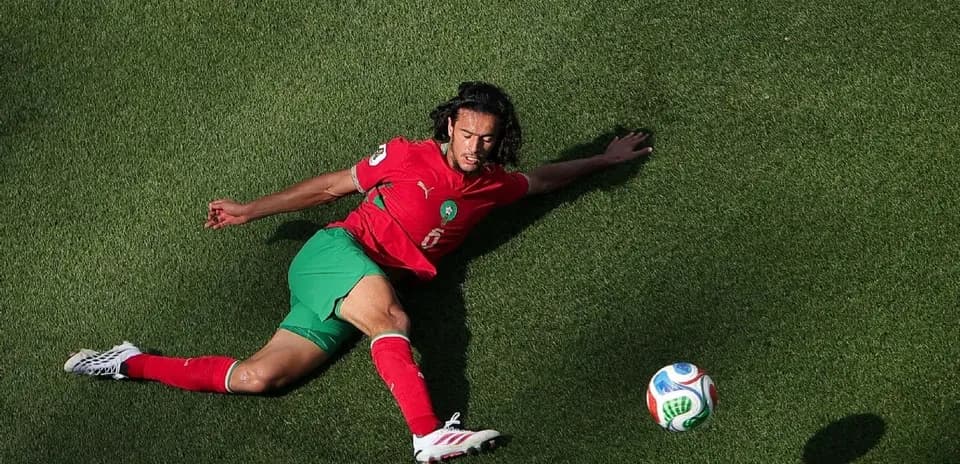 Moroccan player sliding on grass towards the ball