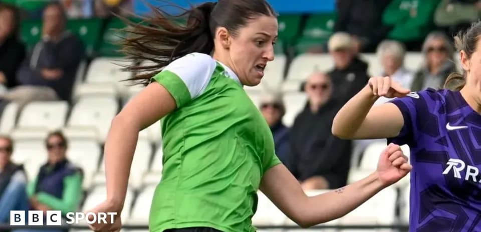 Player in green shirt dribbling past opponent in purple