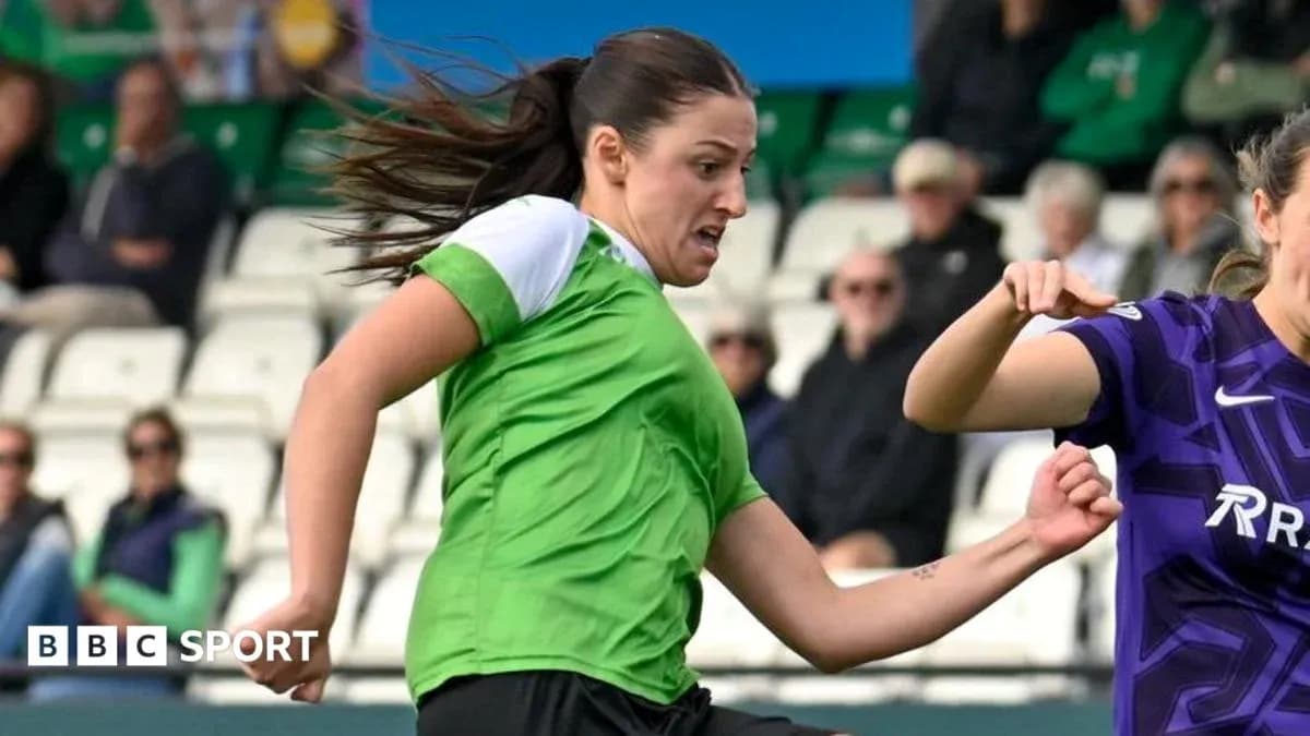 Player in green shirt dribbling past opponent in purple