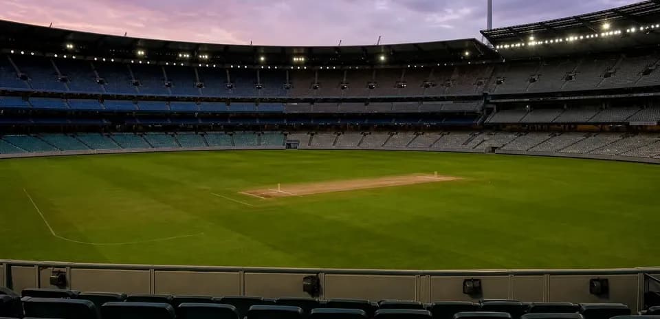 Empty cricket stadium with pitch and seating area