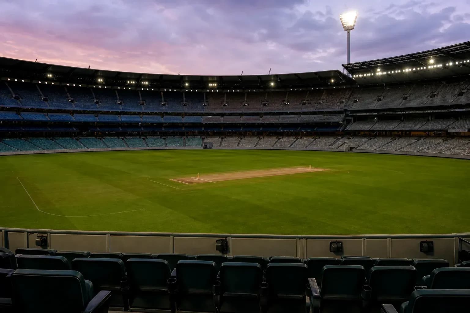 Empty cricket stadium with pitch and seating area