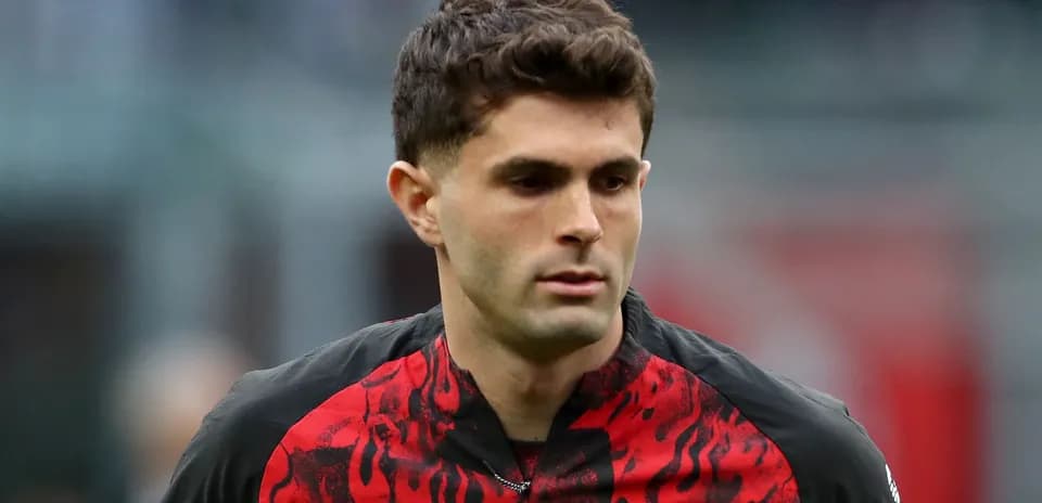Player walking on the pitch in AC Milan jersey