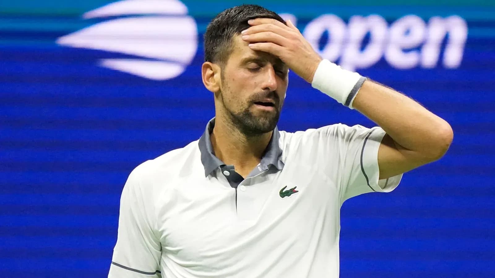 Tennis player with hand on forehead during match