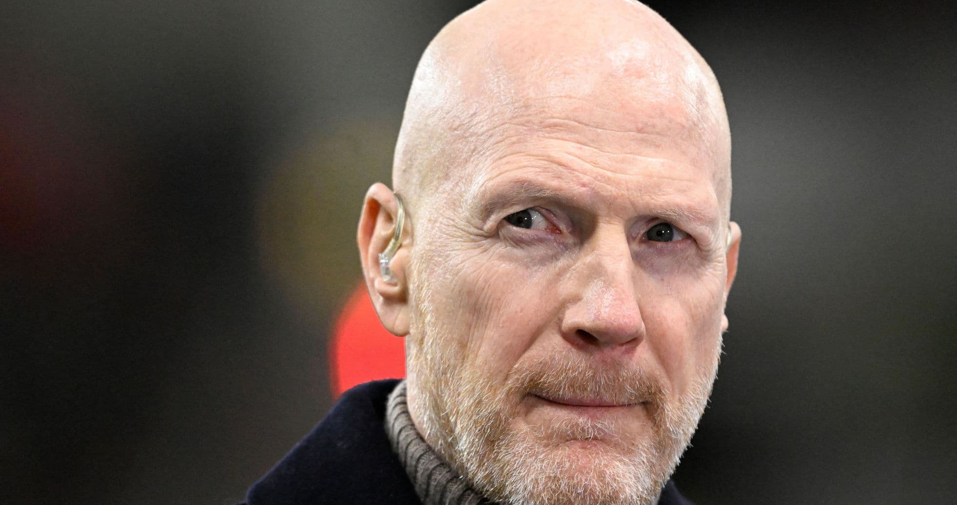 Man with bald head and beard wearing earpiece