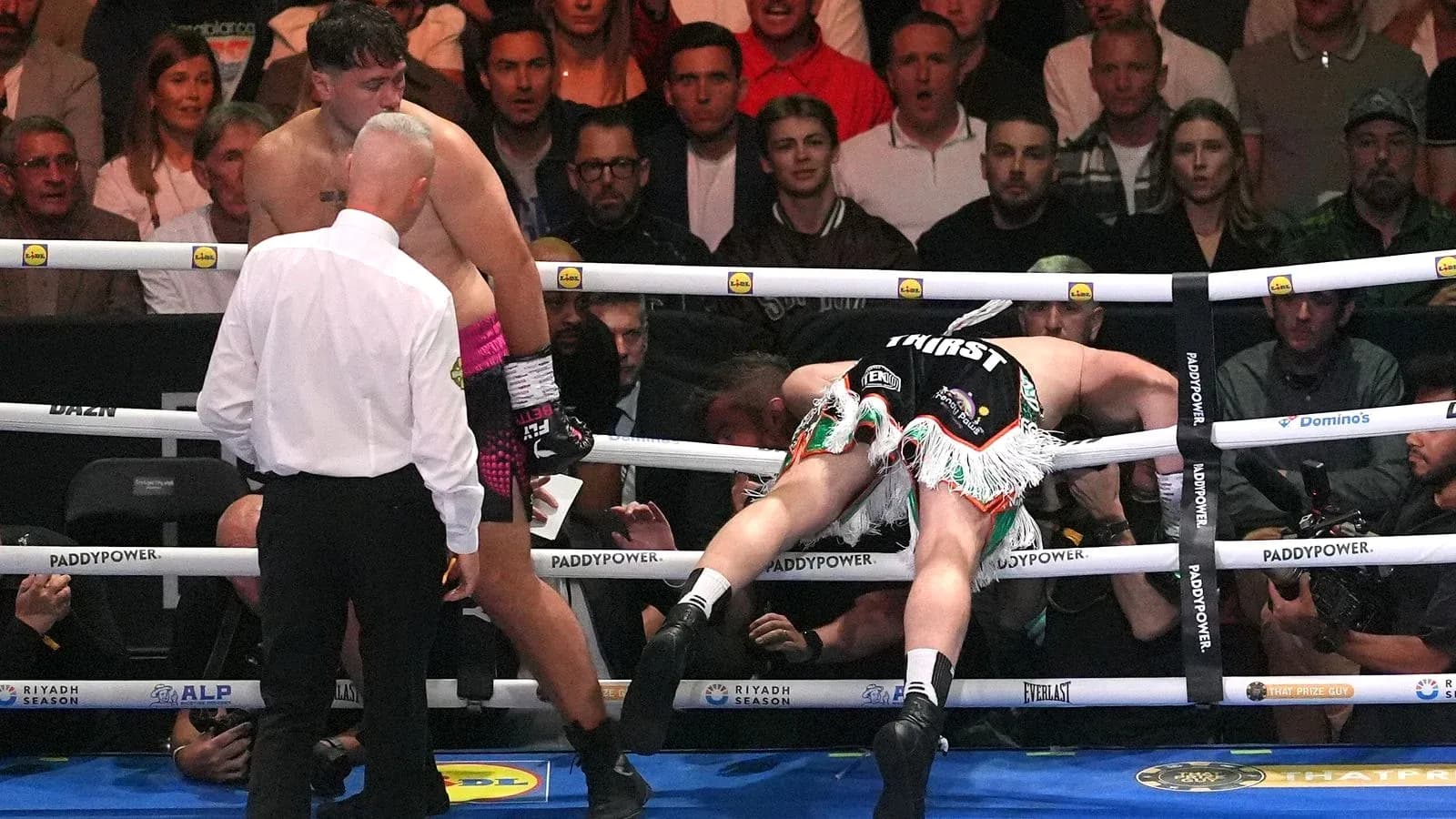 Boxer knocked down against the ropes in the ring