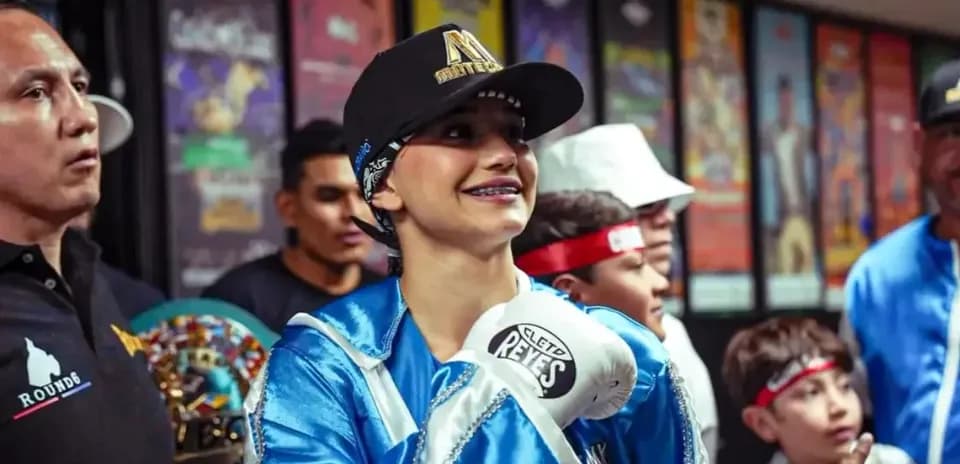 Young female boxer smiling with gloves before match