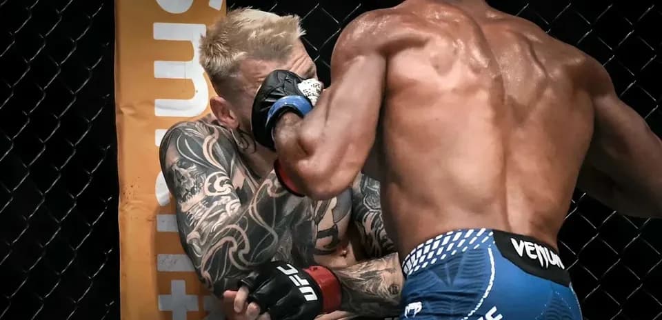 Two fighters engaged in a close combat in octagon