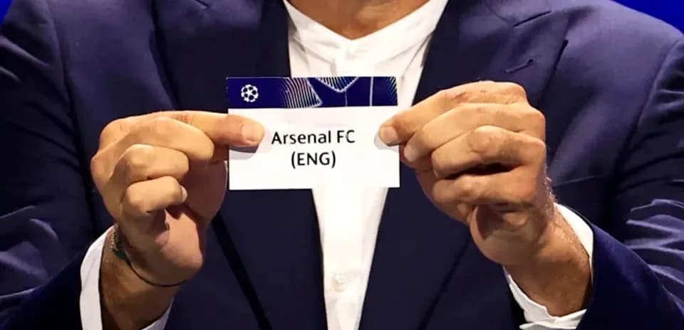 Person holding Arsenal FC draw card at event