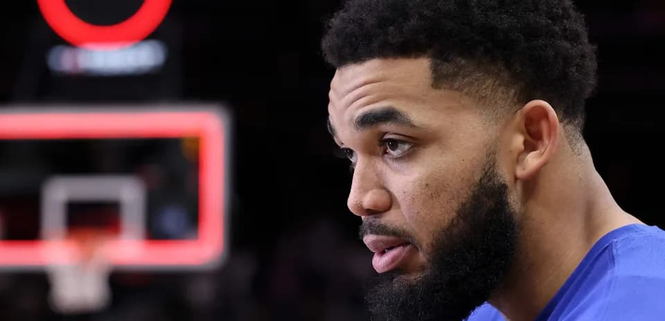Player sitting near basketball hoop during game