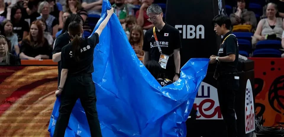 Staff covering court with blue tarp during event