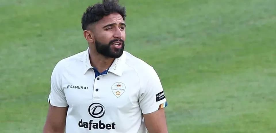 Cricketer in white uniform during match action