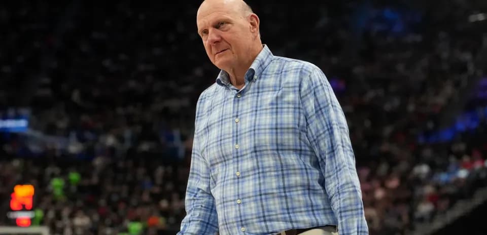 Man in plaid shirt on basketball court sidelines