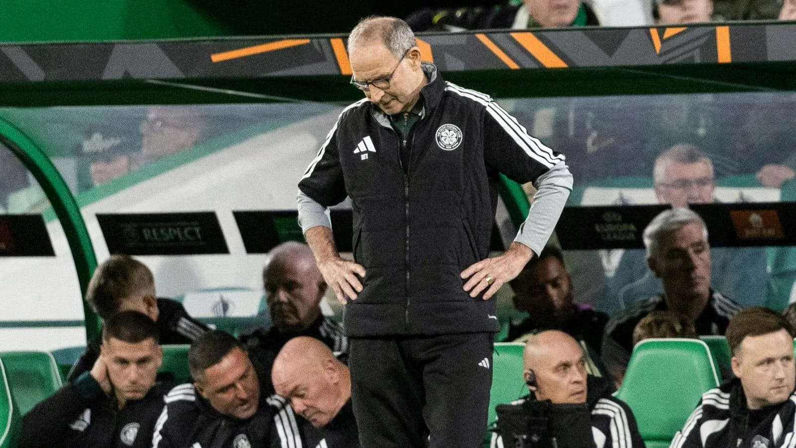 Manager standing on sidelines with concerned expression
