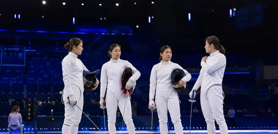 Four fencers discussing on the competition floor