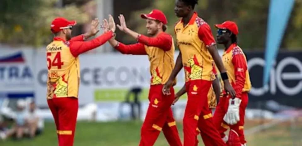 Cricket players celebrating a wicket on the field