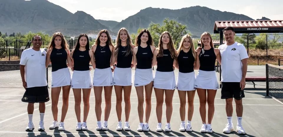Tennis team posing together on outdoor court