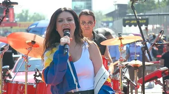 Singer performing on stage with band during event