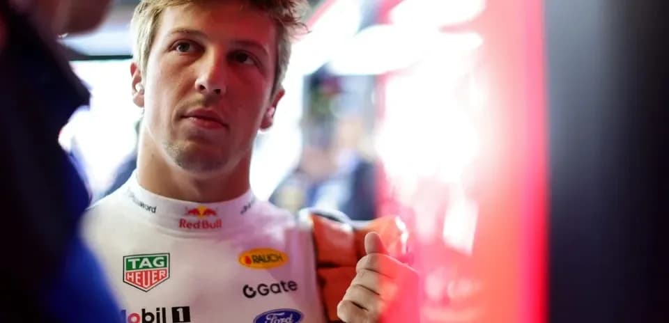 Driver in racing suit preparing in the garage