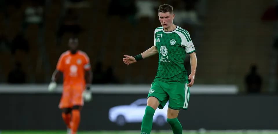 Player in green uniform dribbling the ball