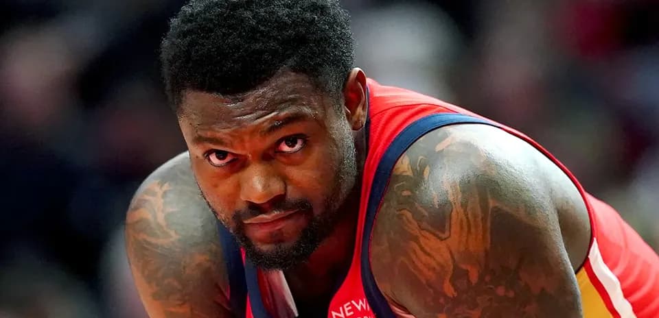 Basketball player in red jersey looking towards camera