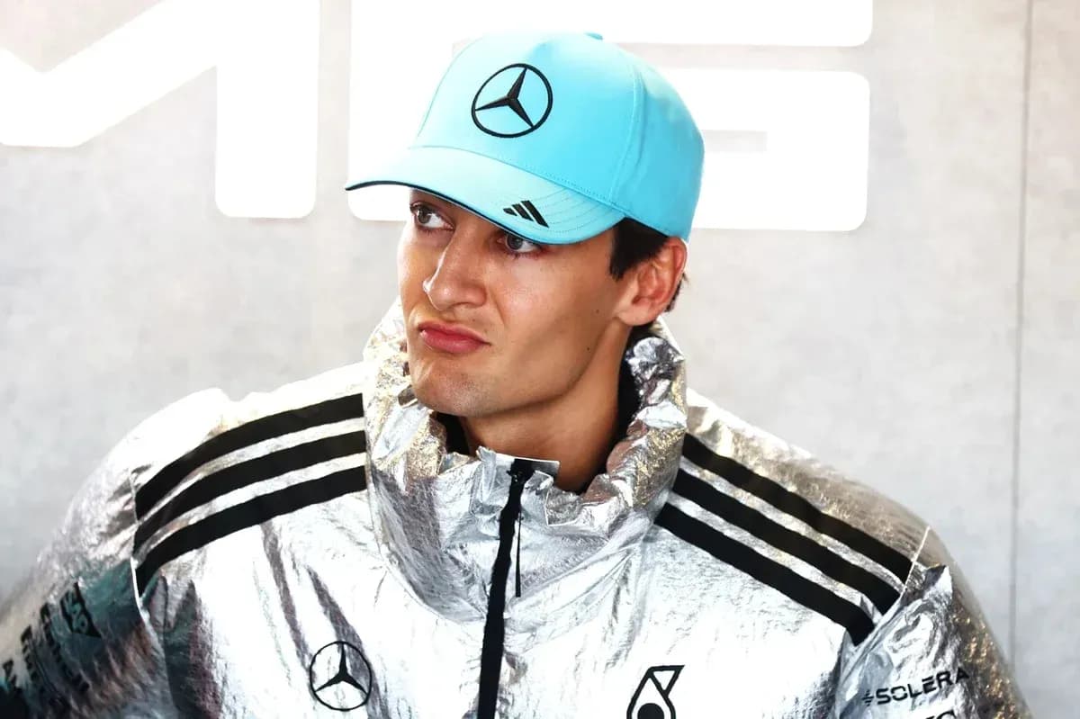 Driver wearing a silver jacket and blue cap