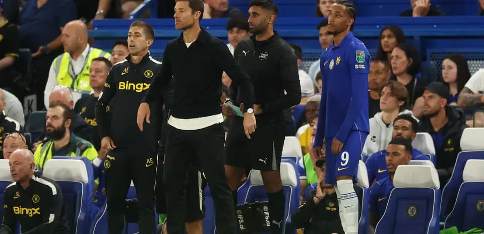 Coaching staff and player on the sidelines during match