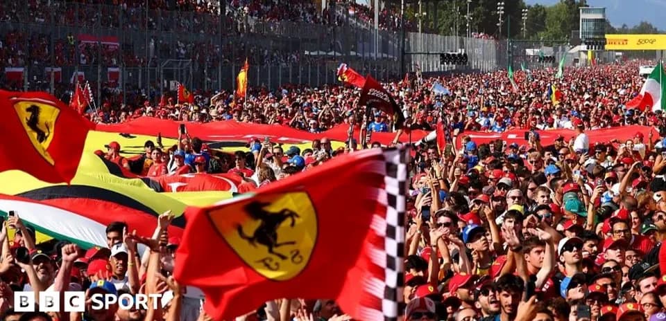 Large crowd of Ferrari fans waving flags at event