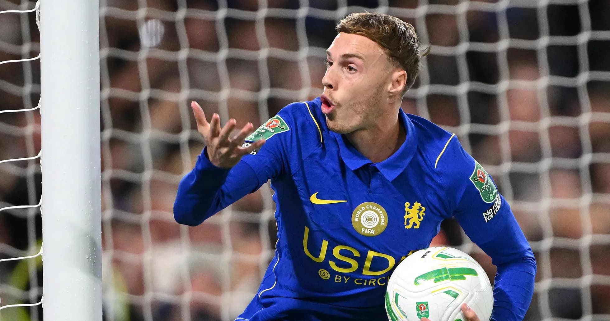 Player in blue jersey gesturing with ball in hand