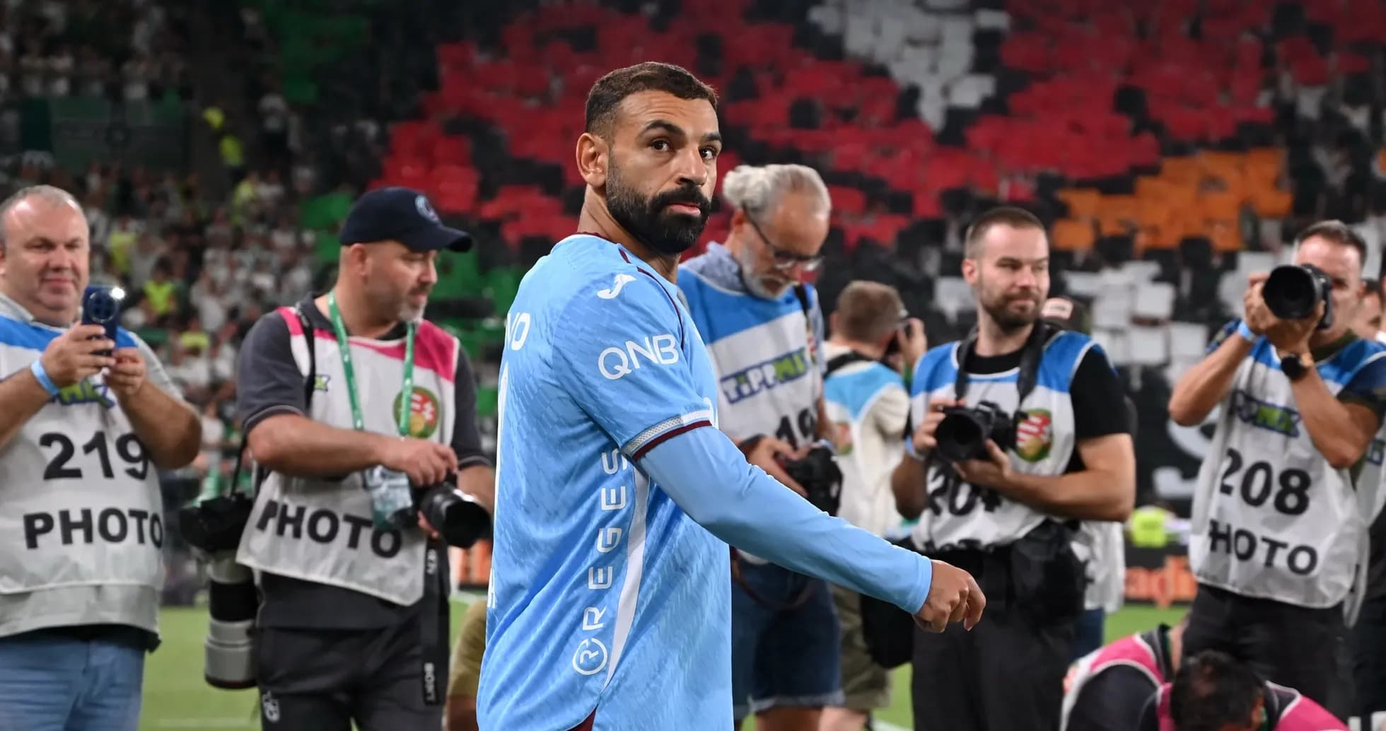 Player walking past photographers on the field