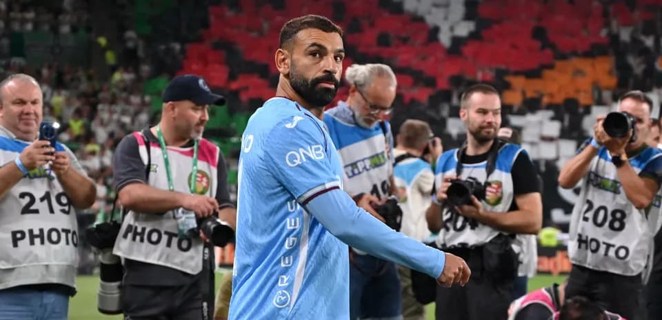 Player walking past photographers on the field