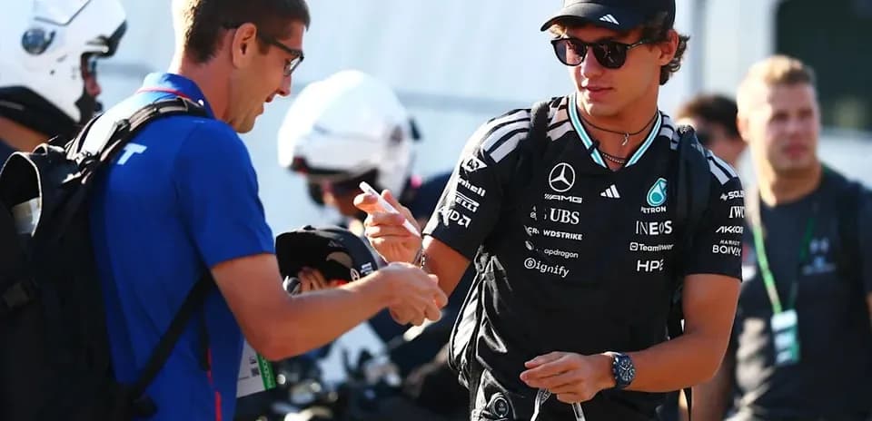 Driver signing autographs for fans in paddock