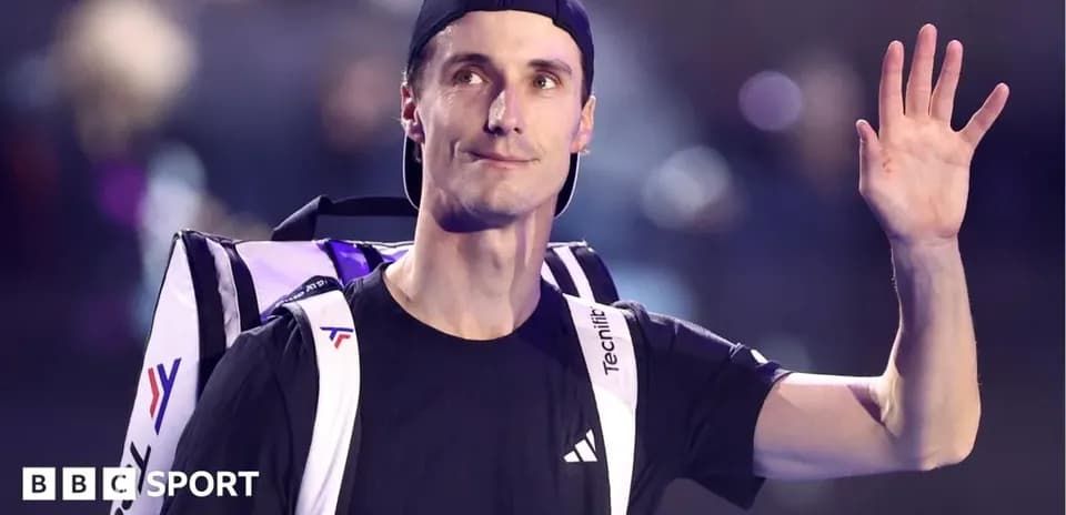 Tennis player waving while carrying a bag
