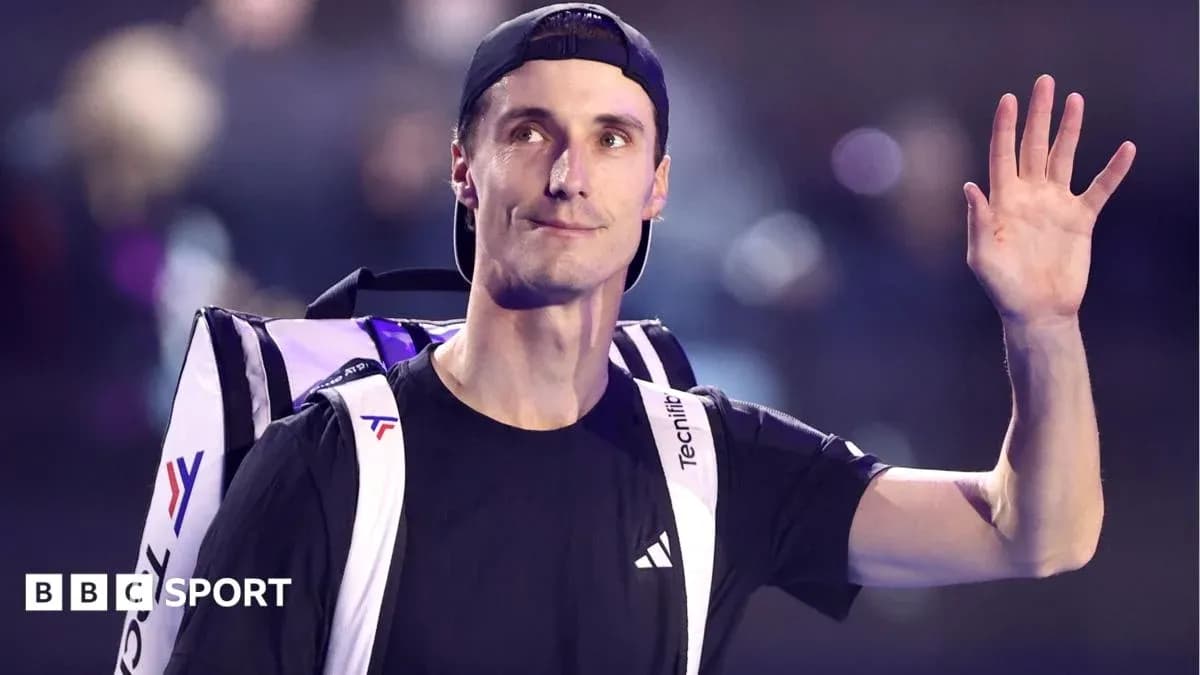 Tennis player waving while carrying a bag