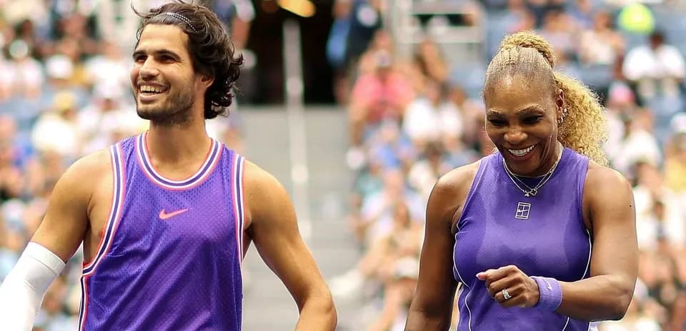 Two tennis players smiling on court after match
