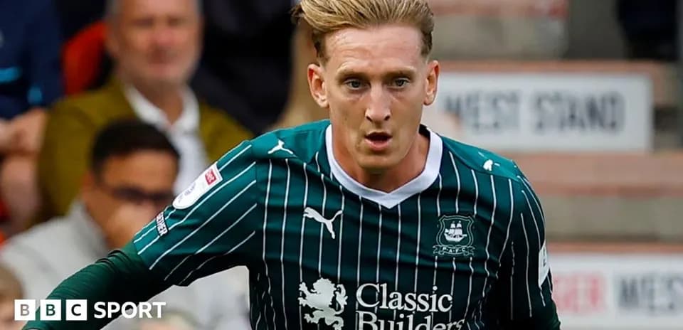 Player running with ball during match in green kit