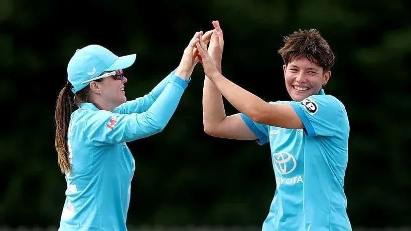 Two players celebrating a wicket in cricket match