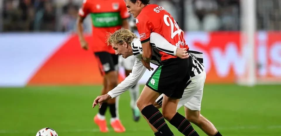 Two players contesting for the ball on field