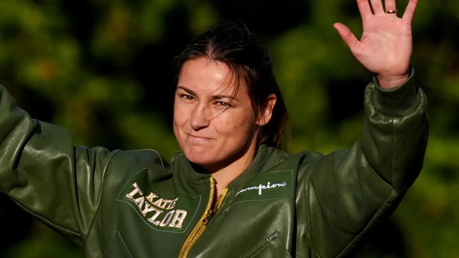 Katie Taylor waving while wearing a green jacket