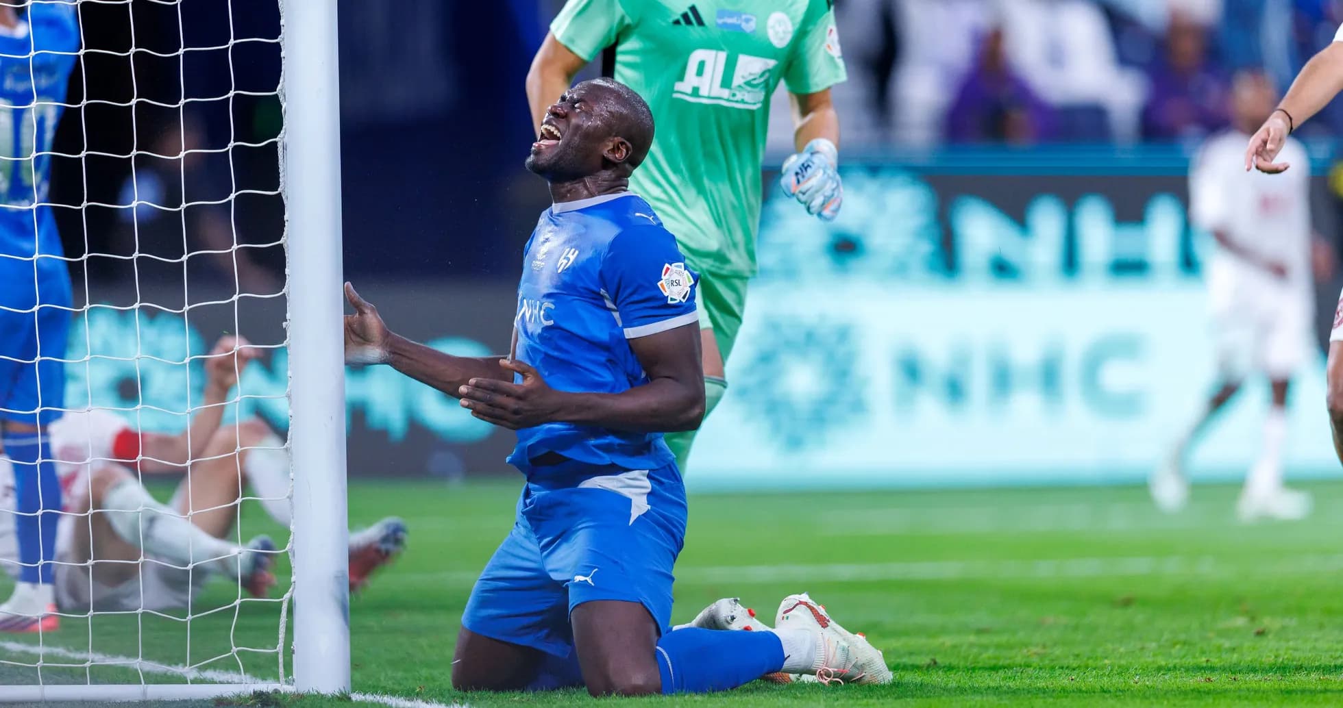Player kneeling in front of goalpost after missed chance