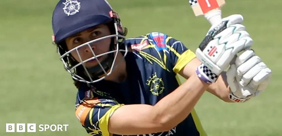 Cricketer batting during a match in uniform