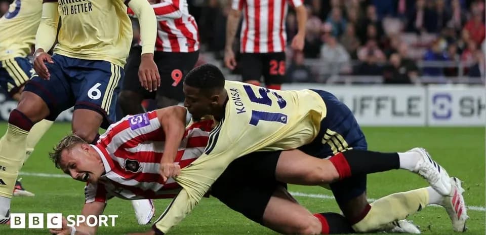 Players tangled during a football match action