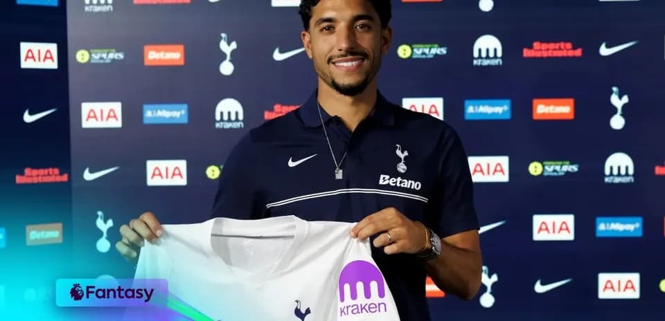Player holding Tottenham Hotspur jersey at press conference
