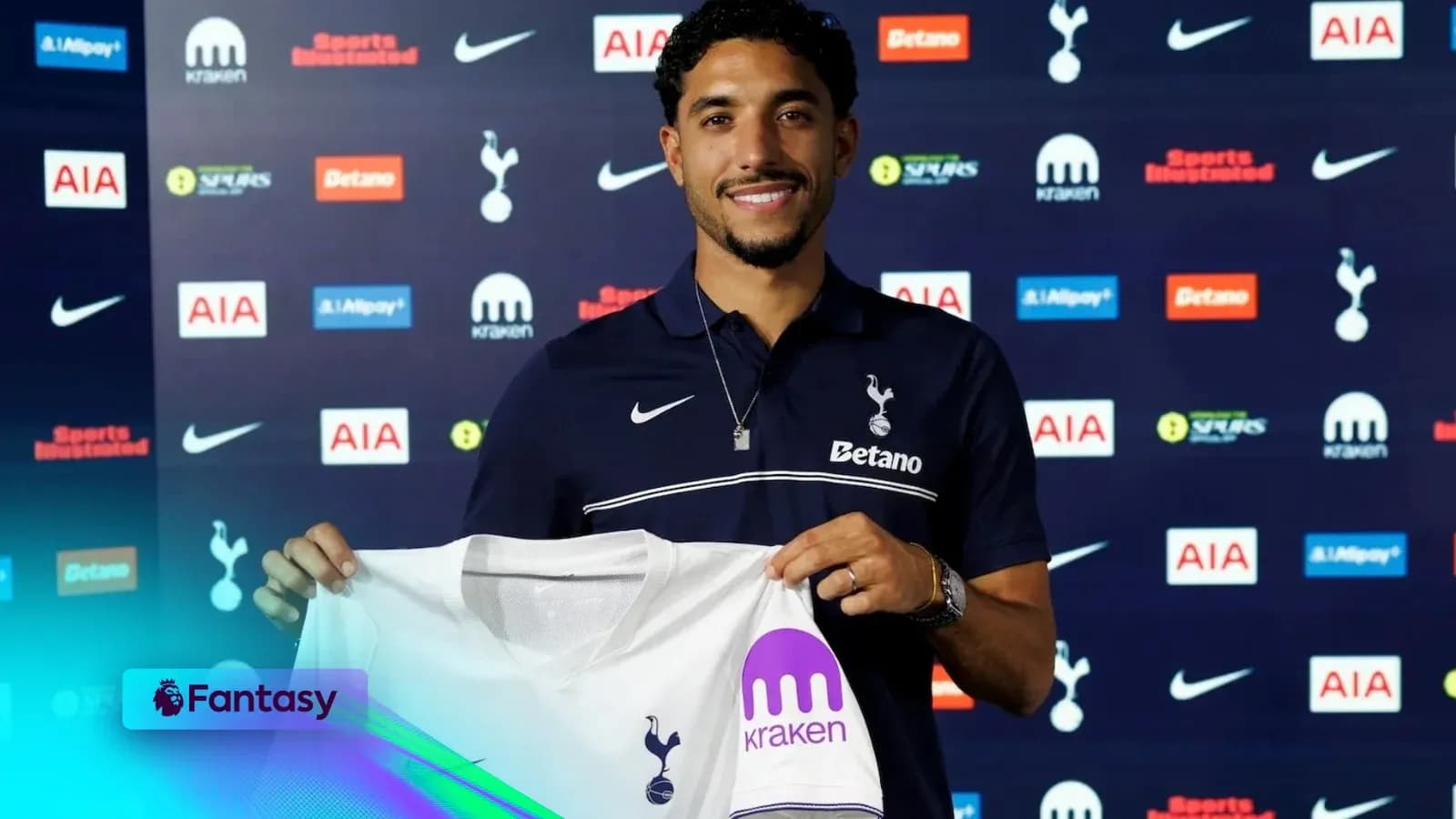 Player holding Tottenham Hotspur jersey at press conference