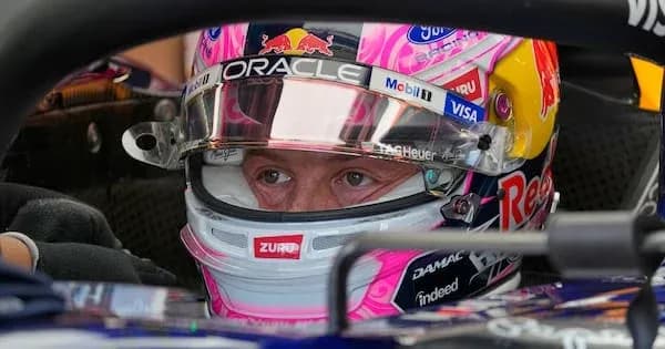 Driver in helmet seated in racing car cockpit